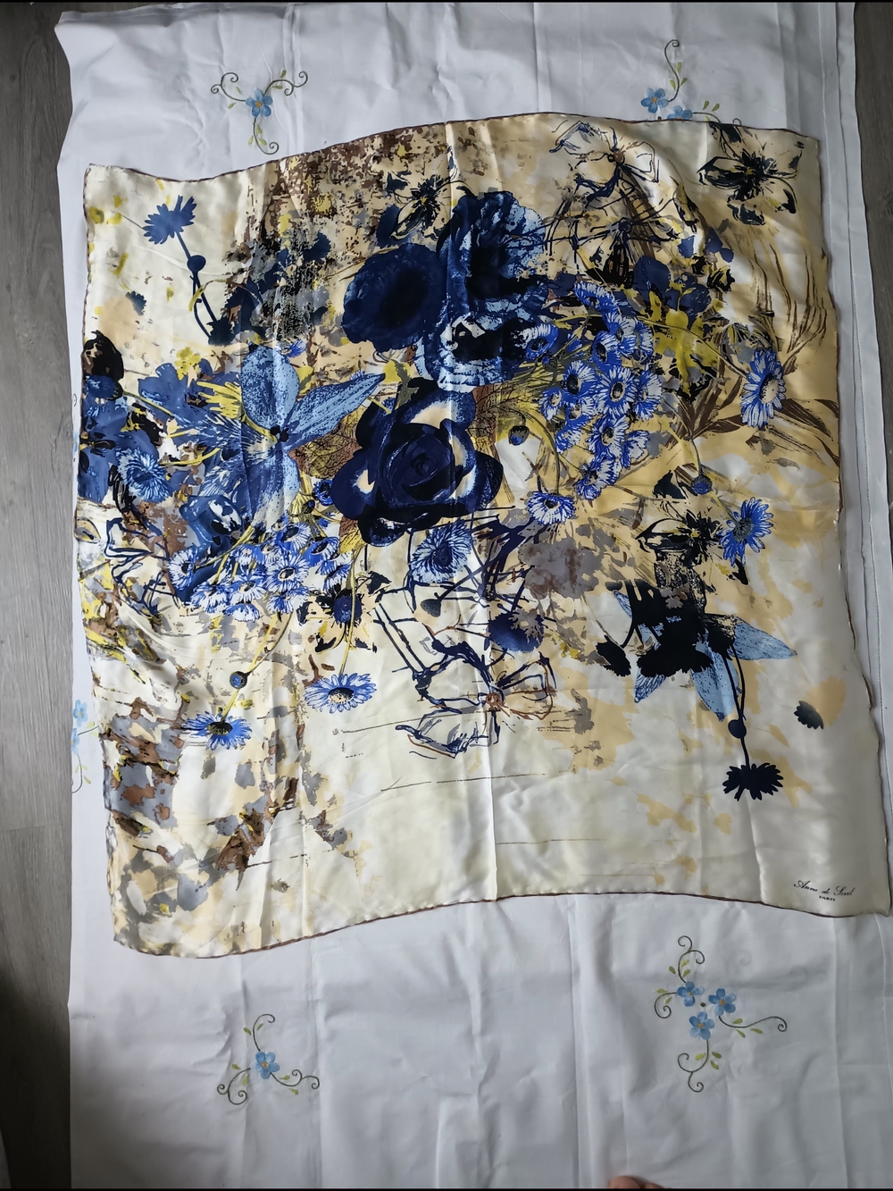 silk scarf from the brand Anne de Sevil features a floral pattern in shades